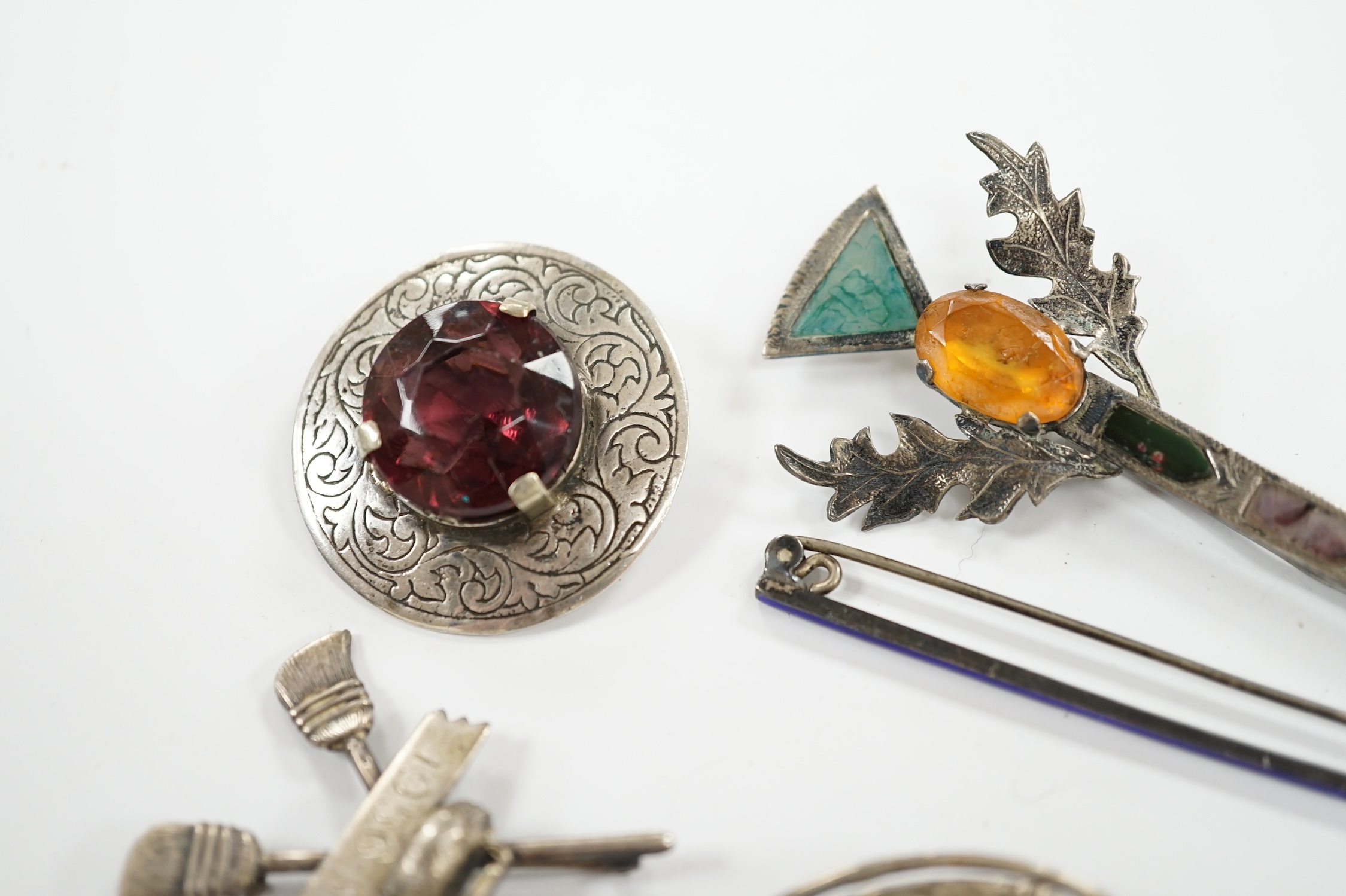 A 1950's Scottish silver, gem and Scottish hardstone set brooch, 91mm, together with six other brooches including four sterling and one silver. Condition - fair